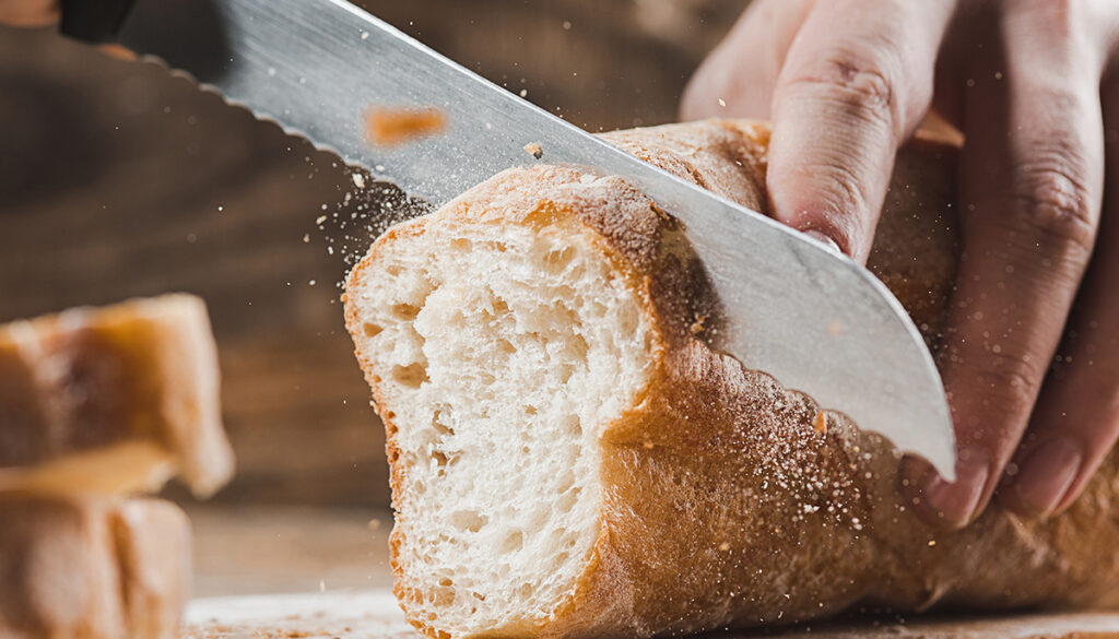 cerrated-knife-cuts-through-baguette bread